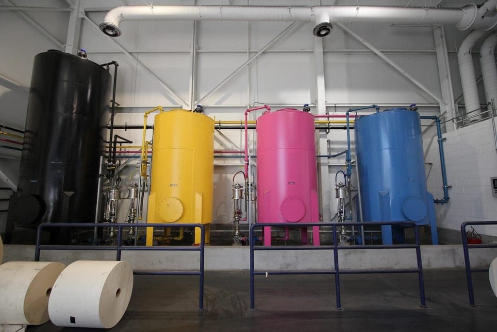 Cyan, magenta and yellow ink tanks in a print facility